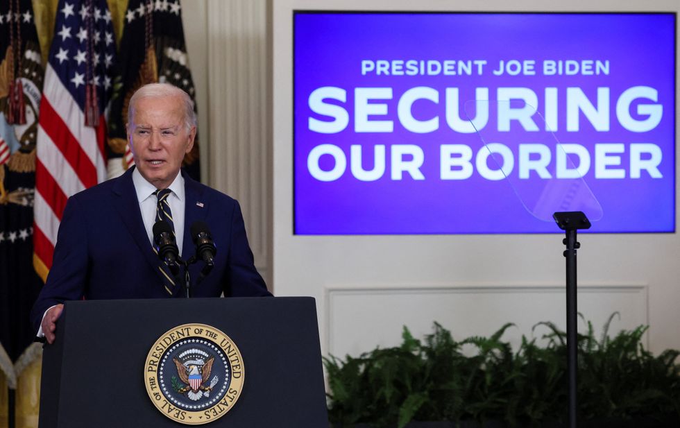 Joe Biden standing in front of a campaign slogan