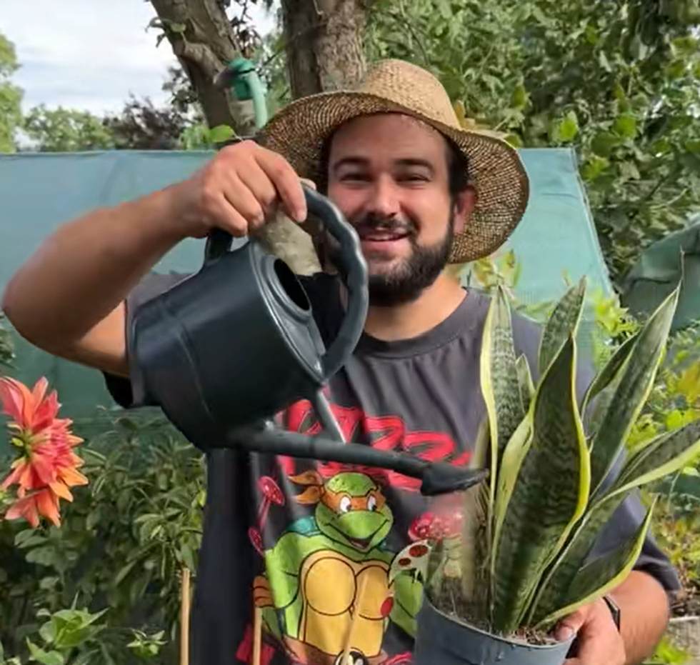 Joe watering his flowers in the garden