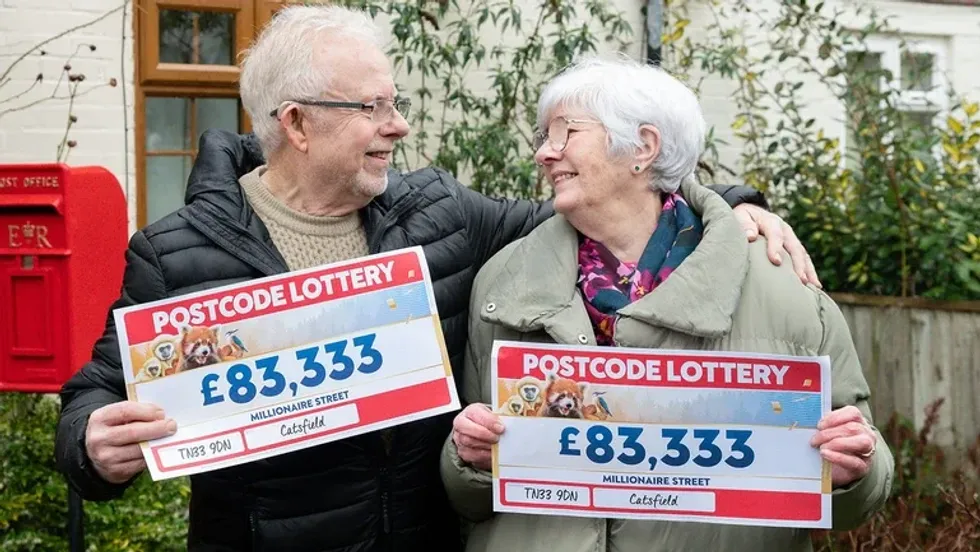 John and Janet Fowle holding up their People's Postcode Lottery cheques