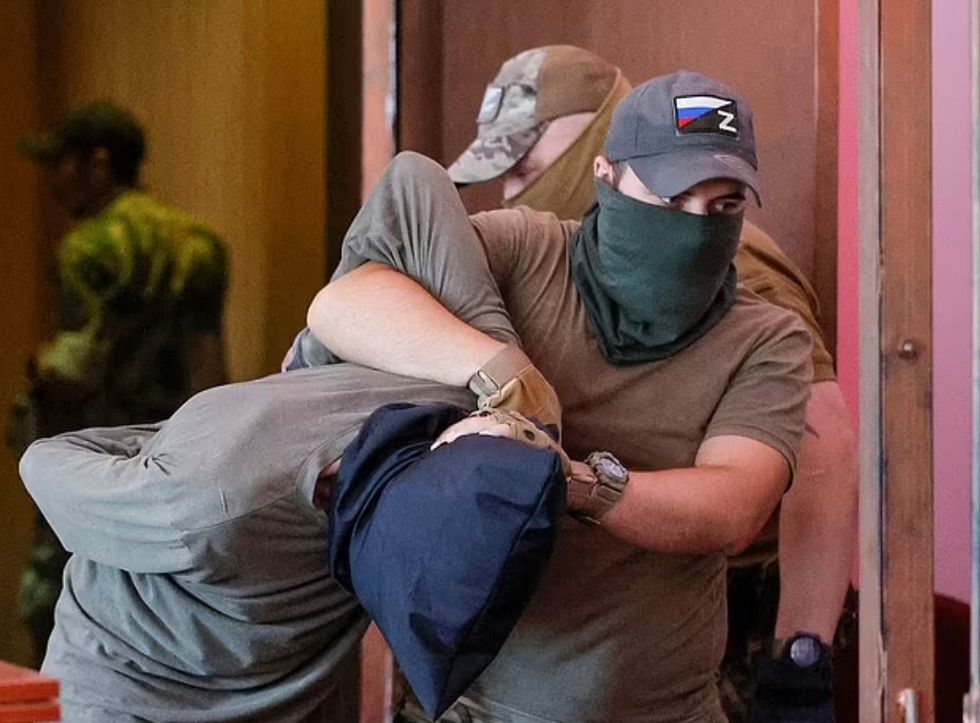 John Harding was wrestled into the dock in Donetsk