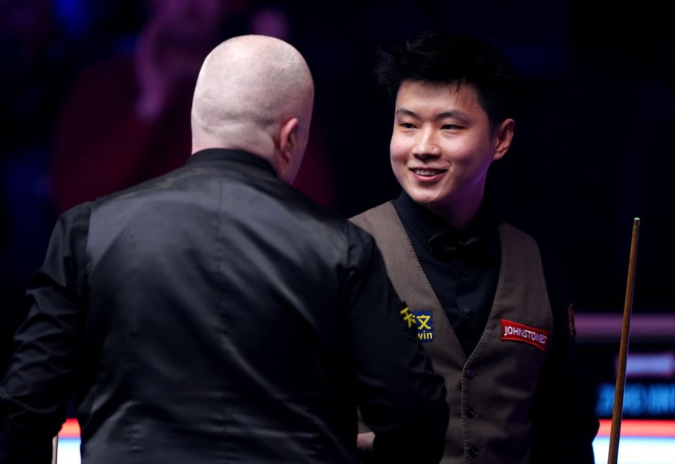 John Higgins and Zhao Xintong shook hands after an incredible match