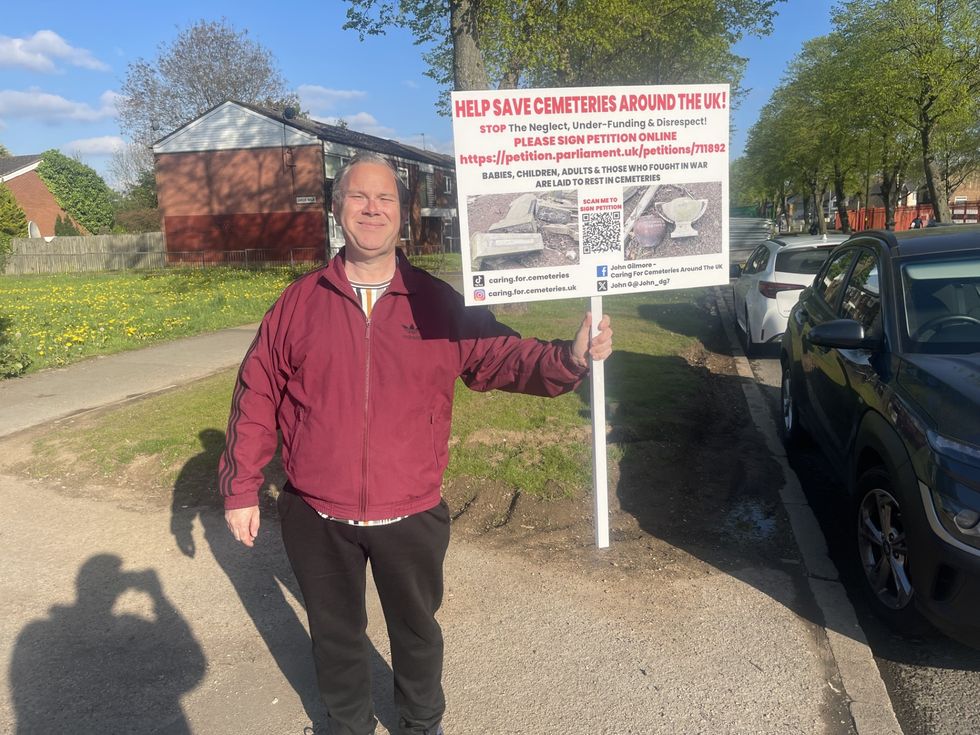 John \u200bGilmore standing by the roadside with his sign