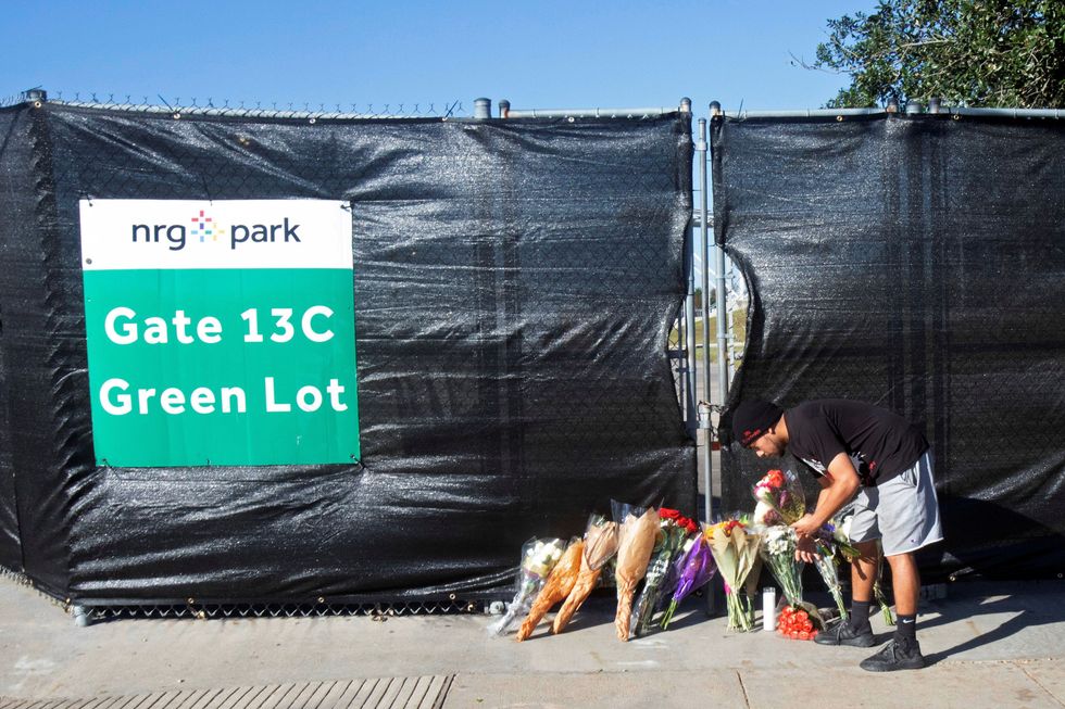 Jonathan Maya places flowers at a gate to NRG Park, after a deadly crush of fans during a performance the night before at the Astroworld Festival by rapper Travis Scott in Houston, Texas, U.S. November 6, 2021. REUTERS/Daniel Kramer