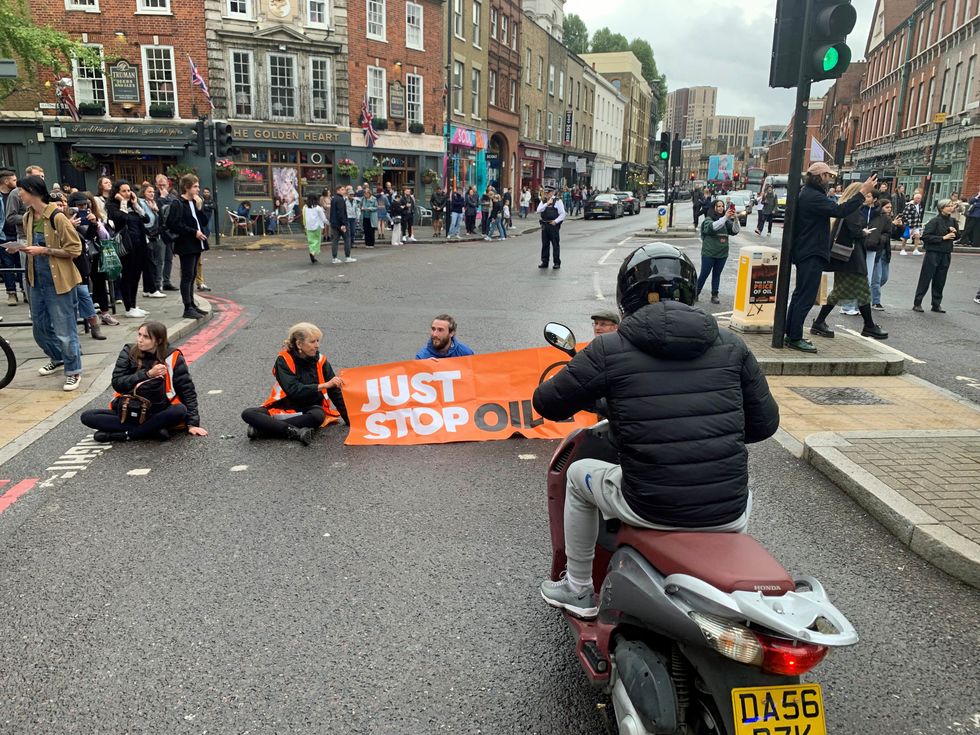 Just Stop Oil activists blocking the road on Commercial Street in east London. Issue date: Sunday October 30, 2022.