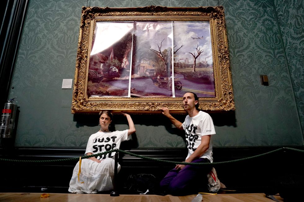 Just Stop Oil climate protest group glued their hands to the frame of John Constable's The Hay Wain after first having covered the painting with their own picture at the National Gallery, London