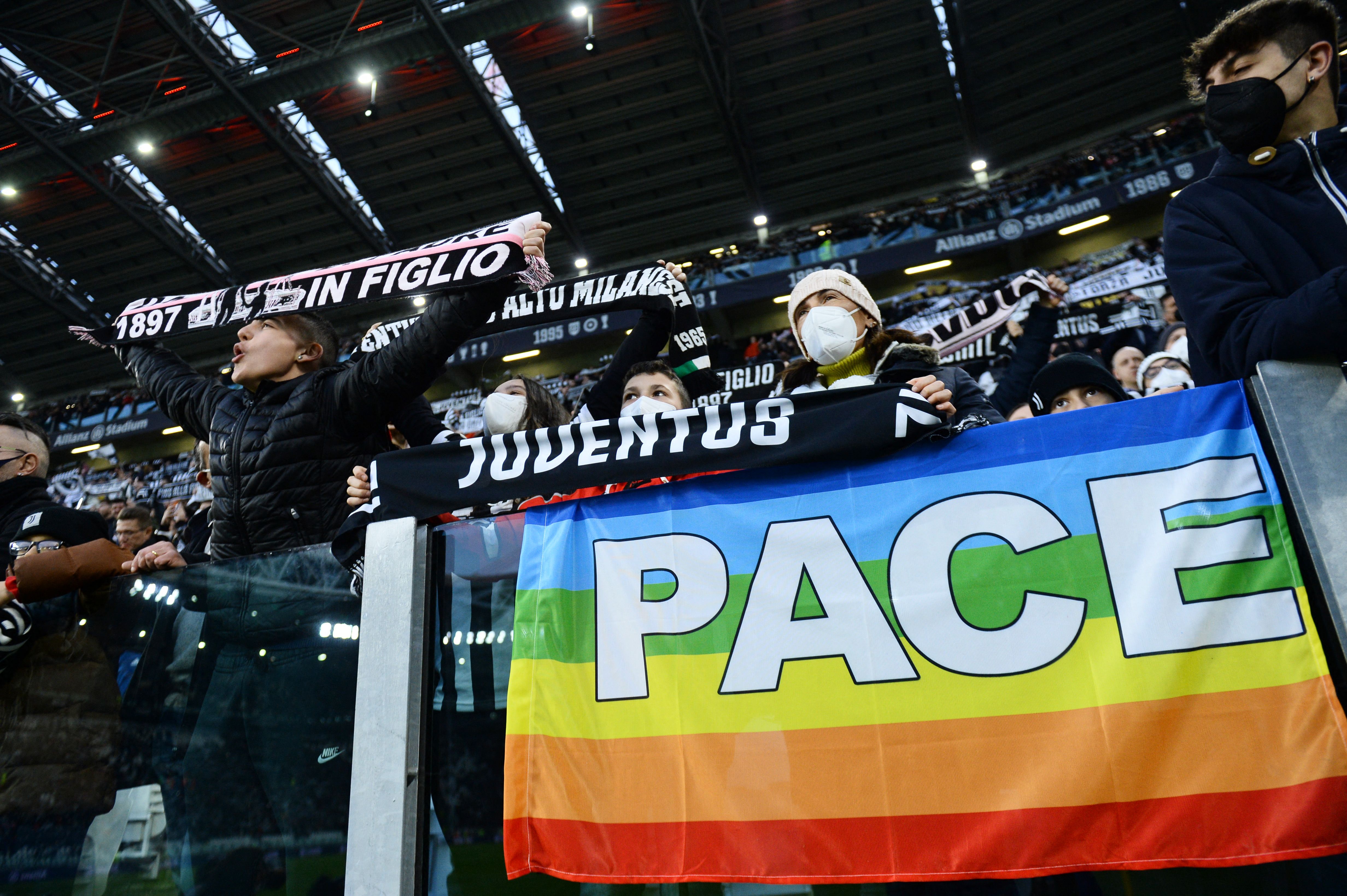 Juventus fans display a rainbow flag that reads 'peace'