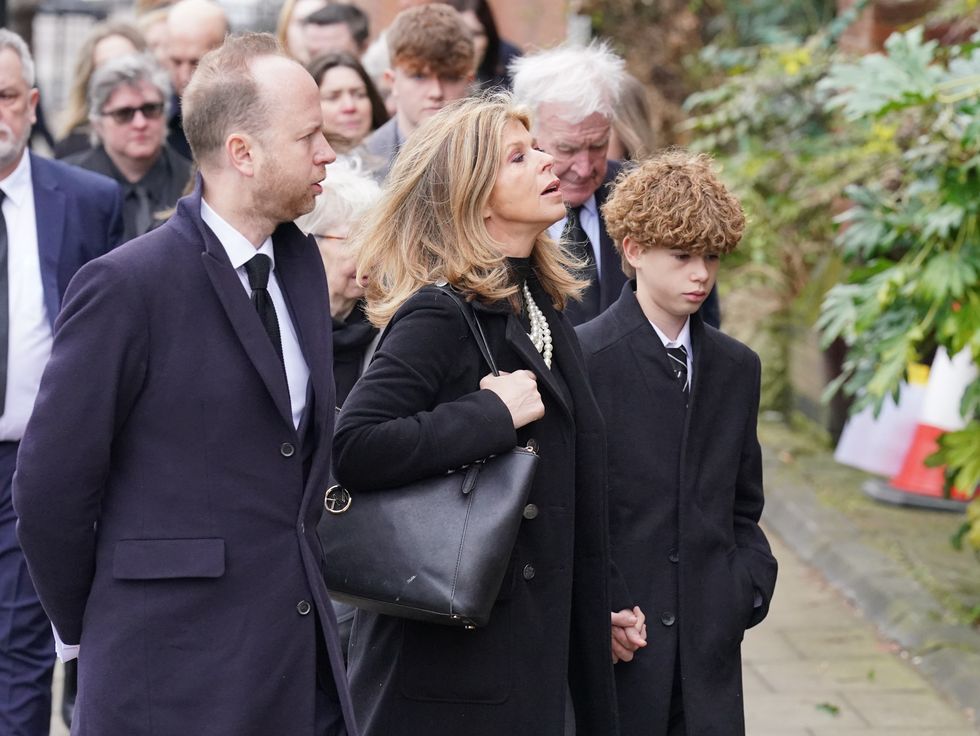 Kate Garraway holds her son's hand as she enters church