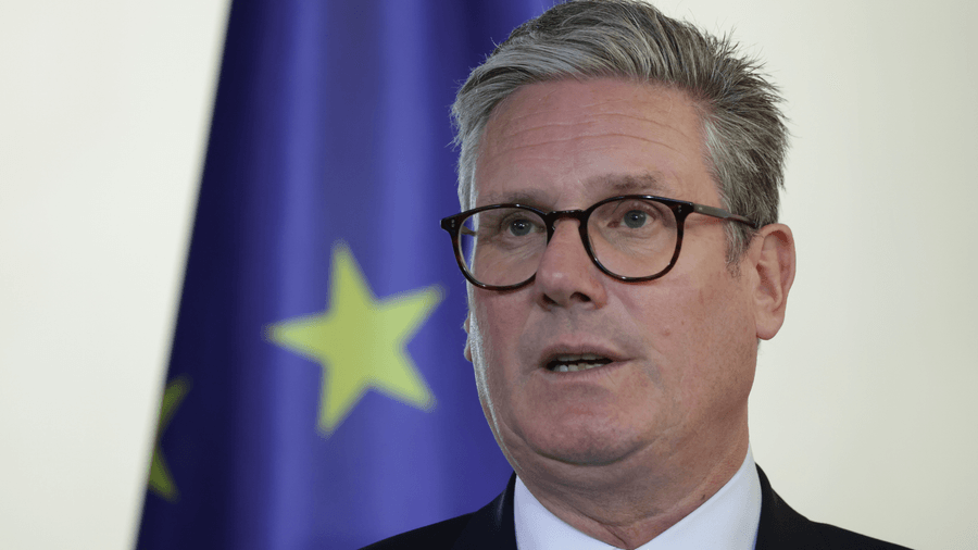 Keir Starmer đứng trước lá cờ EU.