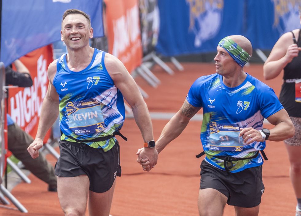 Kevin Sinfield and David Spencer (right) cross the line to complete the Rob Burrow Leeds Marathon