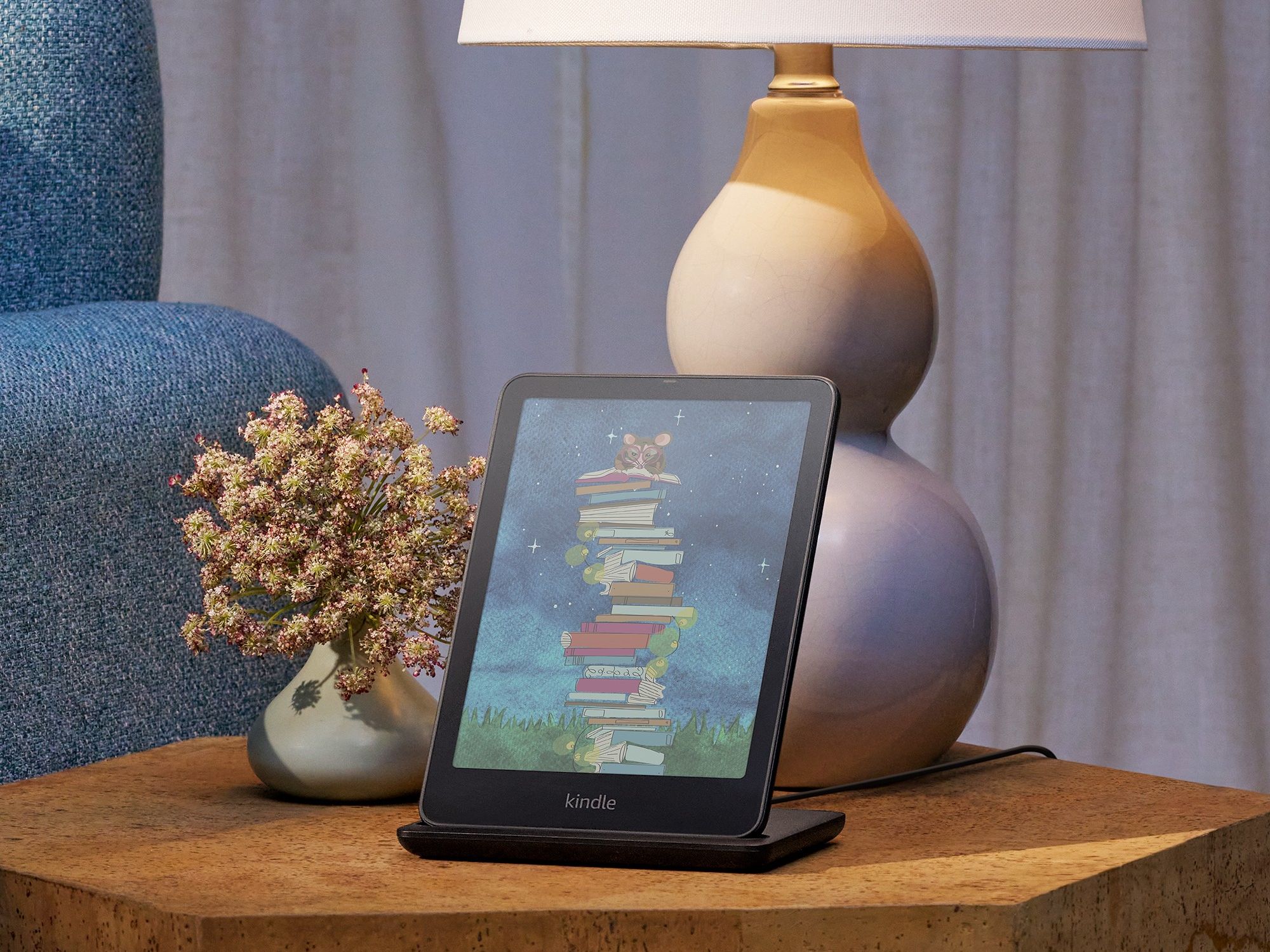 kindle colorsoft pictured on wireless charging stand on a bedside table