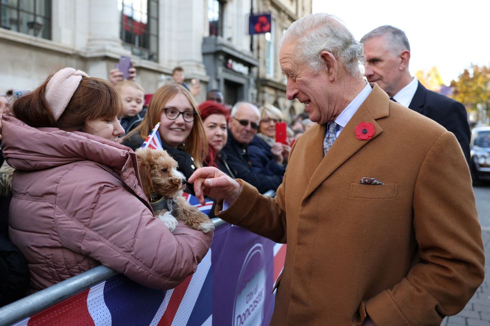 King Charles III is greeted by members of the public and a little dog as he arrives for a ceremony at Mansion House to confer city status on Doncaster.