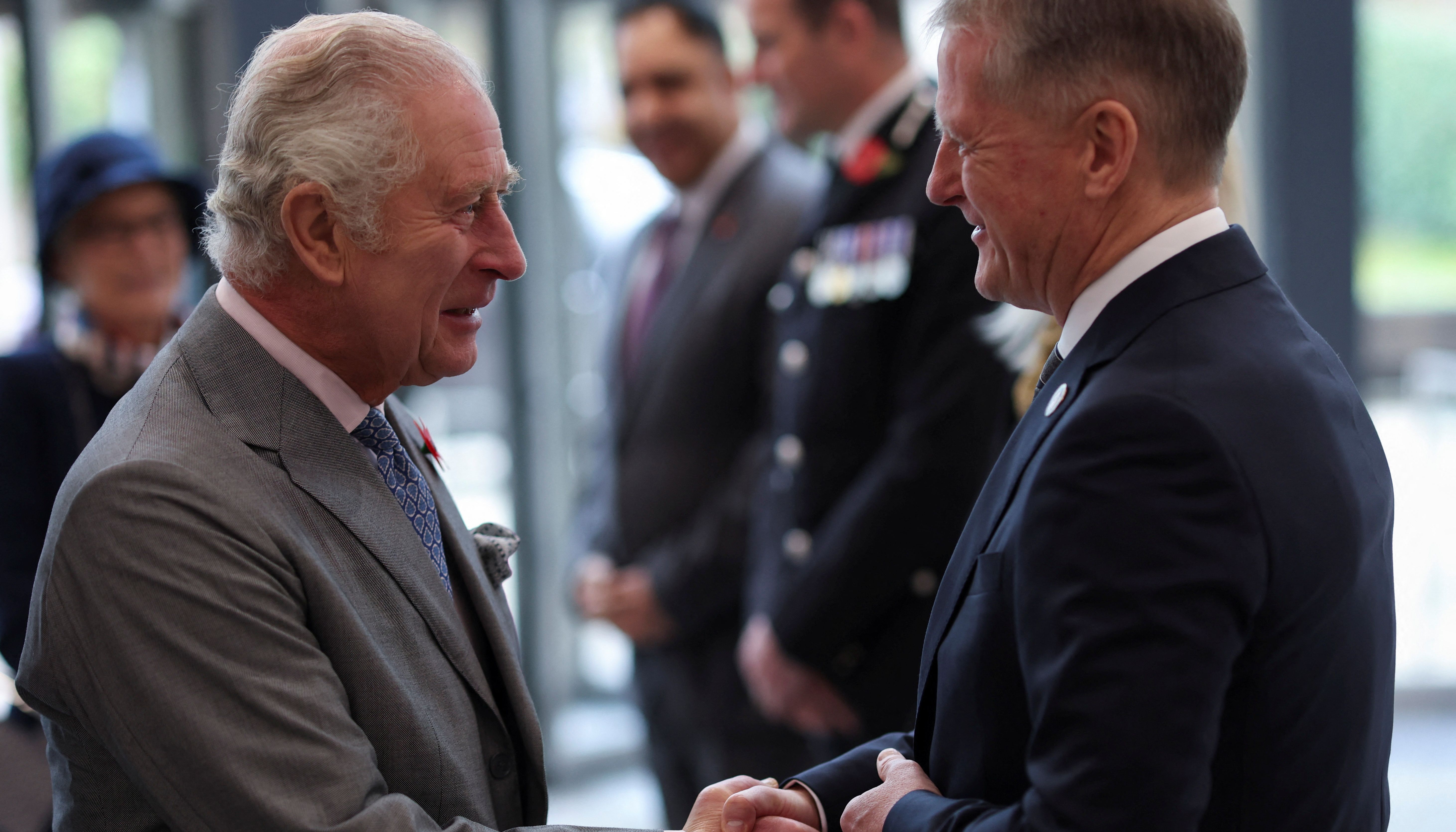 King Charles III shakes hands with David Potts, chief executive of Morrisons Supermarkets.