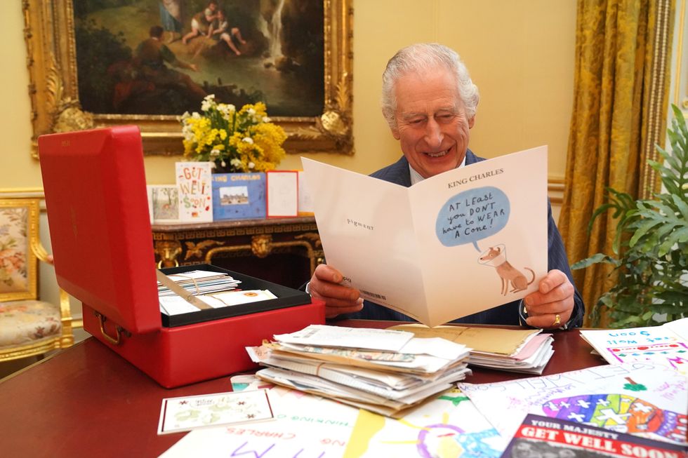 King Charles reading cards from well-wishers