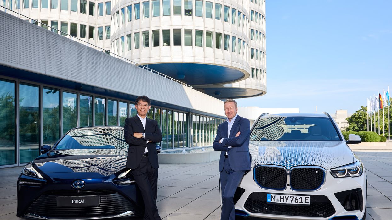 Koji Sato, President of Toyota, and BMW Chairman Oliver Zipse in front of two hydrogen vehicles