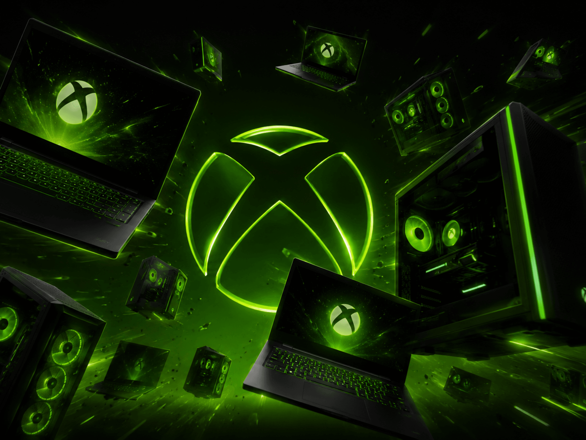laptop and desktop PCs pictured flying towards the camera with the green xbox logo in the background