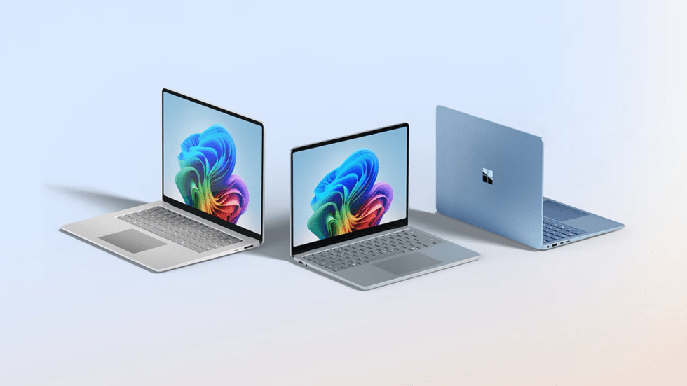 laptops running windows 11 pictured side by side on a plain background