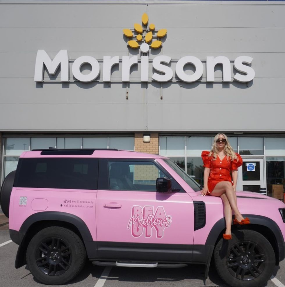 Laura Mallows sitting on a Mallows Beauty car outside Morrisons