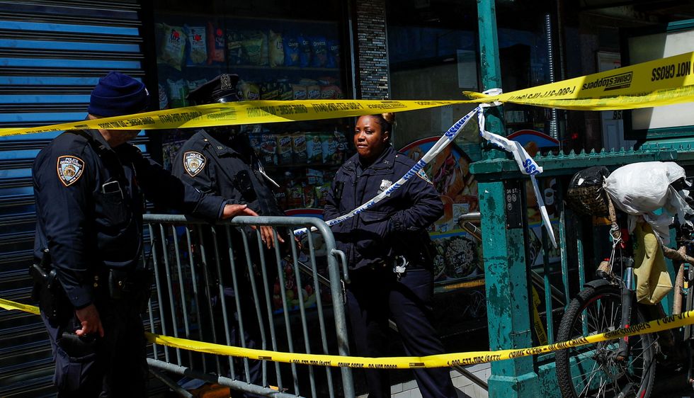 Law enforcement officers stand guard at the scene of a shooting at a subway station in the Brooklyn borough of New York City
