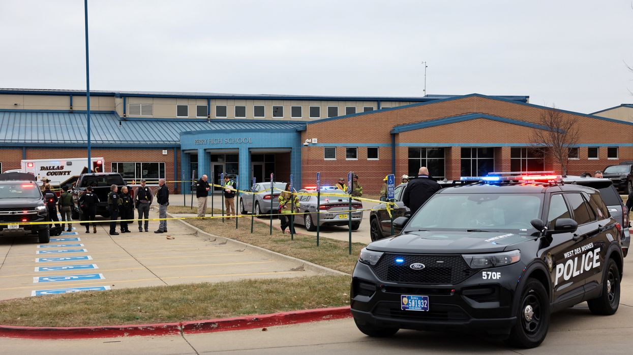 Law enforcement officers work at the scene of a shooting at Perry High School in Perry