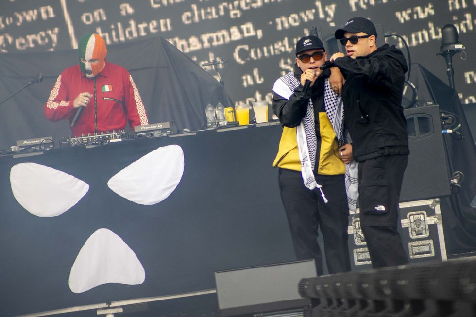 (left to right) JJ O'Dochartaigh (DJ Provai) , Liam Og O Hannaidh (Mo Chara) wearing a keffiyeh, and Naoise O Caireallain (Moglai Bap) performing on stage at London's Finsbury Park