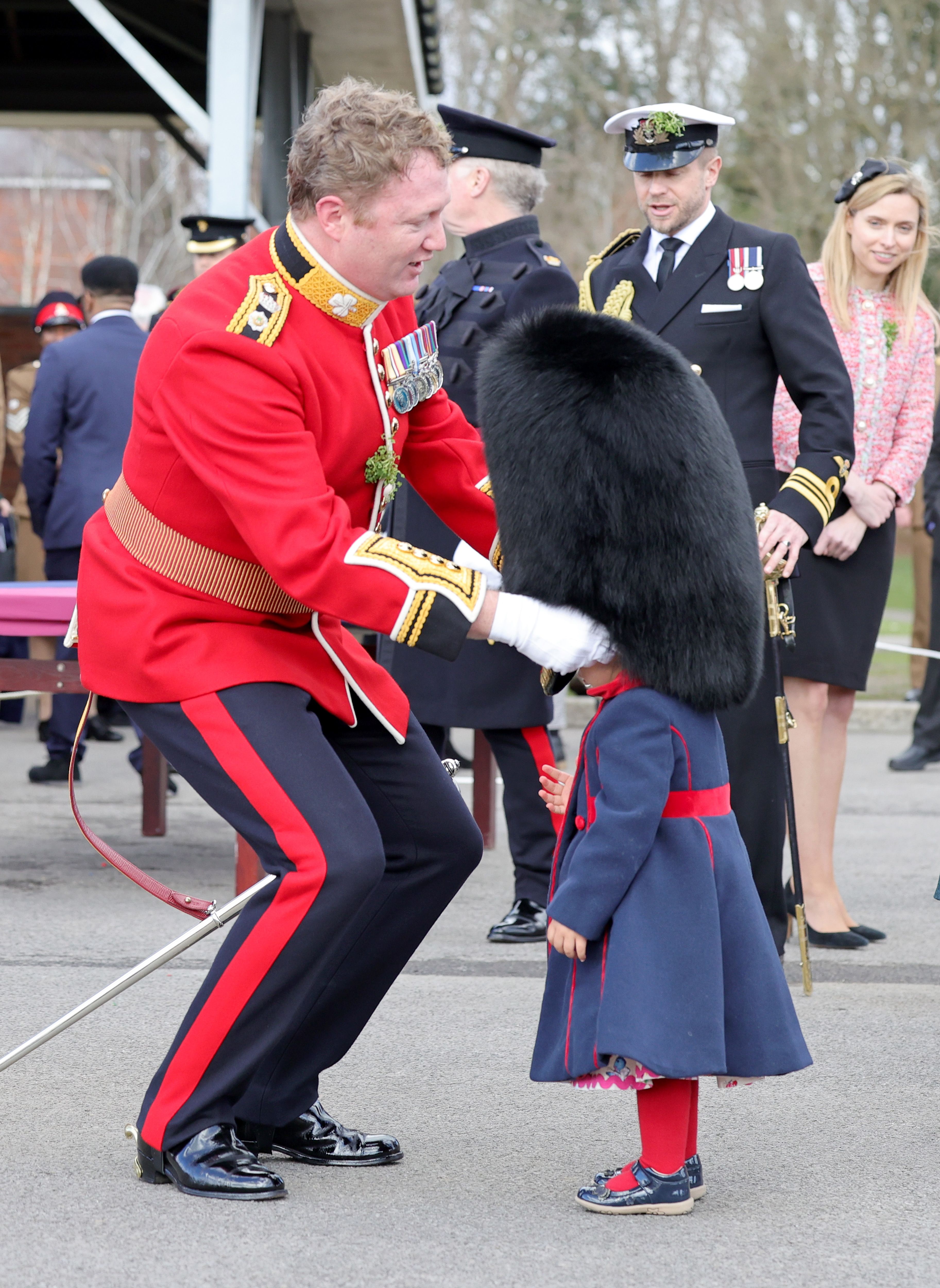 Lieutenant Colonel Rob Money puts a bearskin hat on his 20-month-old daughter Gaia Money's head at the 1st Battalion Irish Guards for the St Patrick's Day Parade, at Mons Barracks in Aldershot