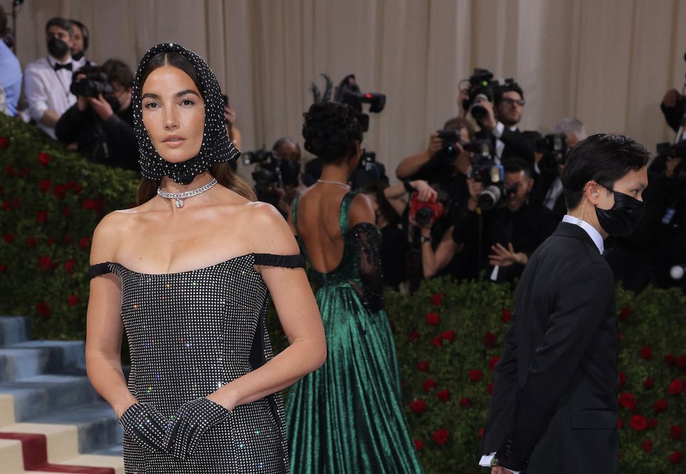 Lily Aldridge at the event, flanked by a mask-wearing member of staff