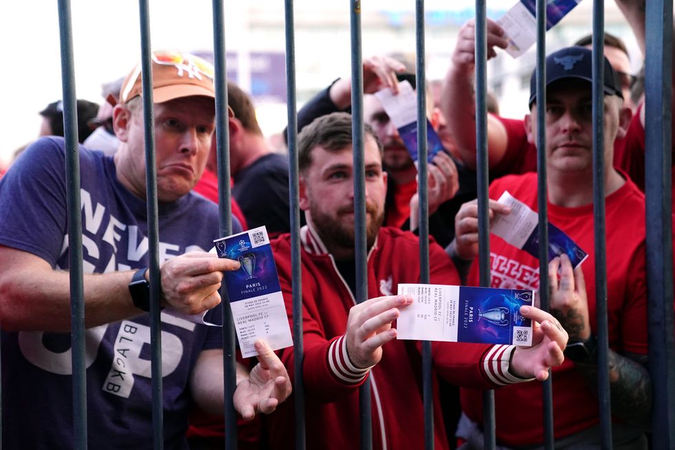 Liverpool fans stuck outside the ground show their match tickets during the UEFA Champions League Final at the Stade de France, Paris