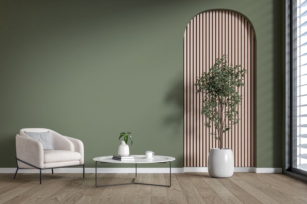 Living room with white furniture, a plant, and olive green walls