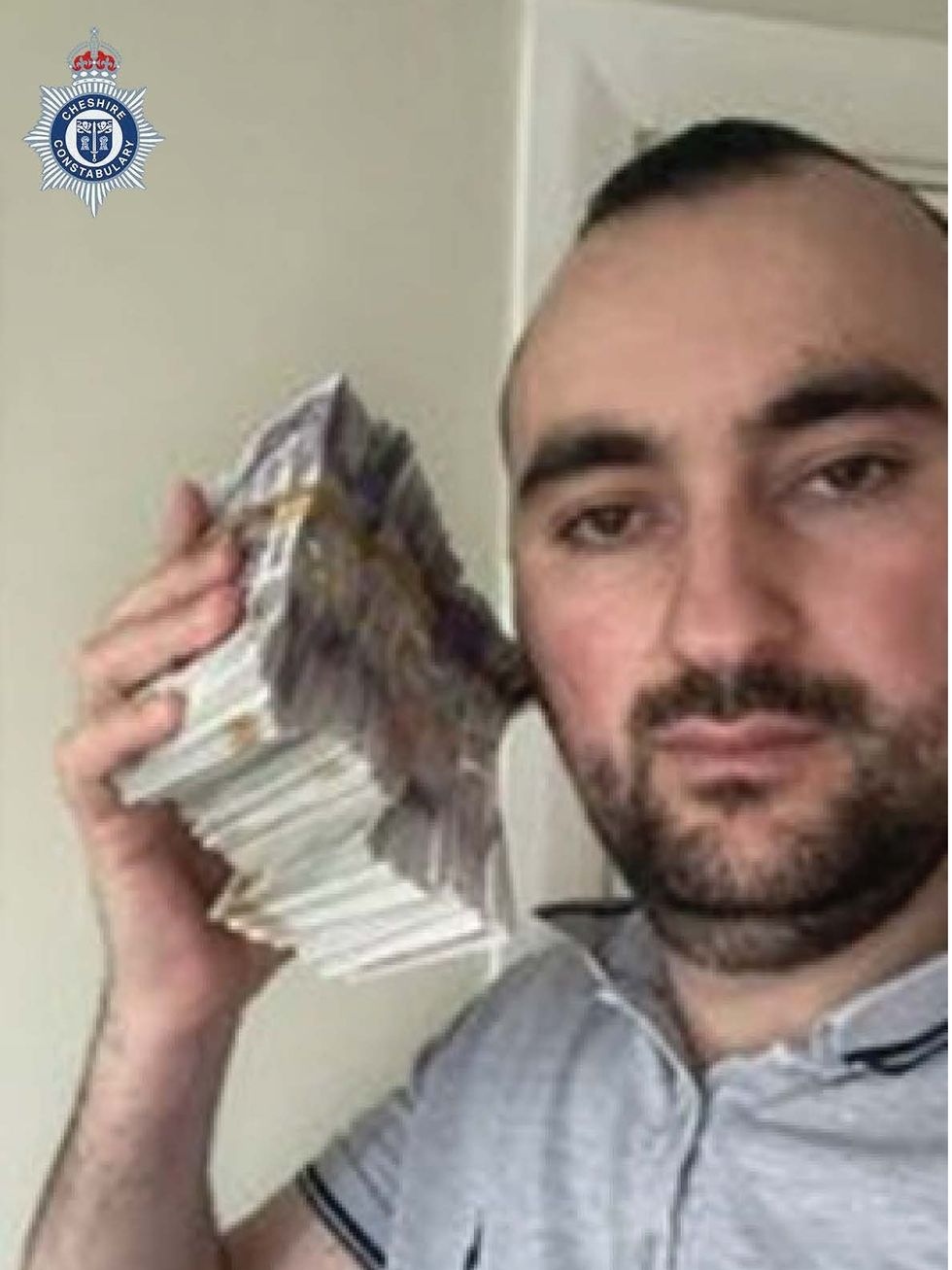 Lleshi posing with money believed to have been burgled