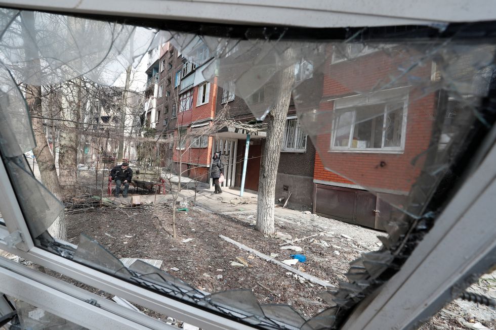 Local residents gather in the courtyard of an apartment building damaged in the course of Ukraine-Russia conflict in the besieged southern port city of Mariupol, Ukraine March 25, 2022. REUTERS/Alexander Ermochenko