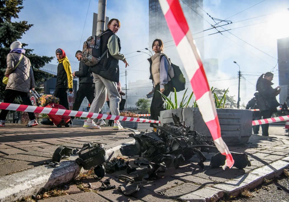 Local residents look at parts of an unmanned aerial vehicle (UAV), what Ukrainian authorities consider to be an Iranian-made drone Shahed-136, after Russian drone strike, amid Russia's attack on Ukraine, in Kyiv, Ukraine October 17, 2022. REUTERS/Vladyslav Musiienko