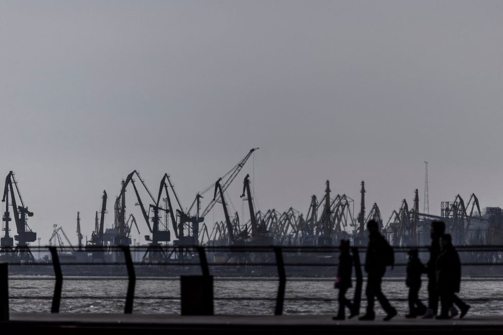 Local residents walks by the port at the industrial city of Mariupol, located about 20 kilometers from the rebel-controlled areas in eastern Ukraine, February 20, 2022. REUTERS/Carlos Barria