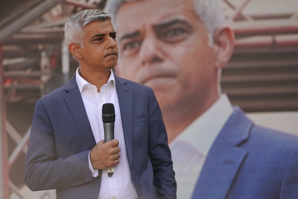 London Mayor Sadiq Khan in front of an image of Sadiq Khan