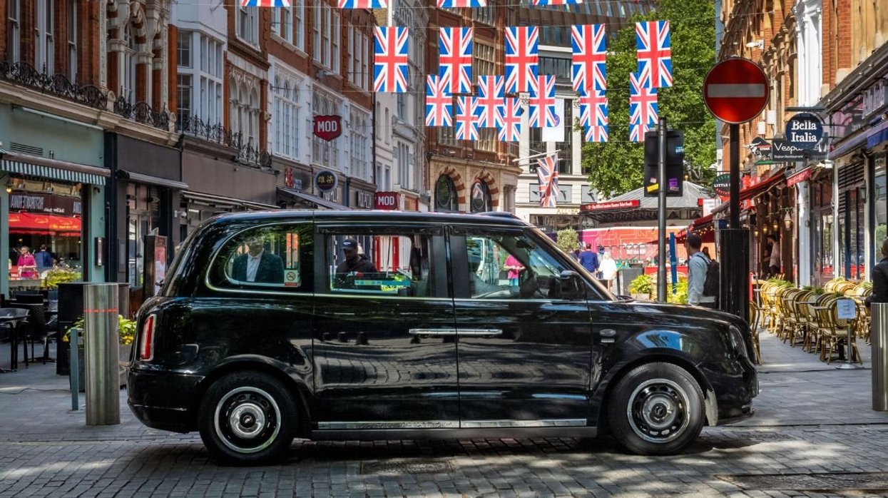 London taxi parked in front of Union Jack flags