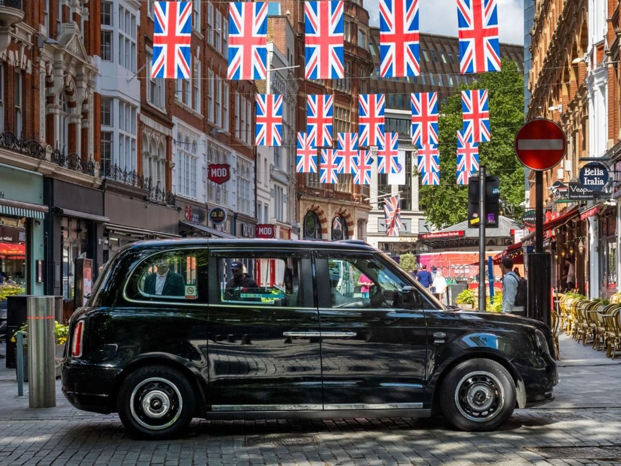 London taxi parked in front of Union Jack flags