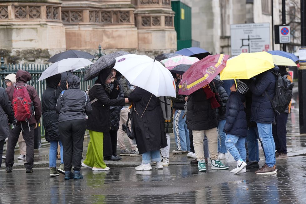 Londoners with umbrellas up