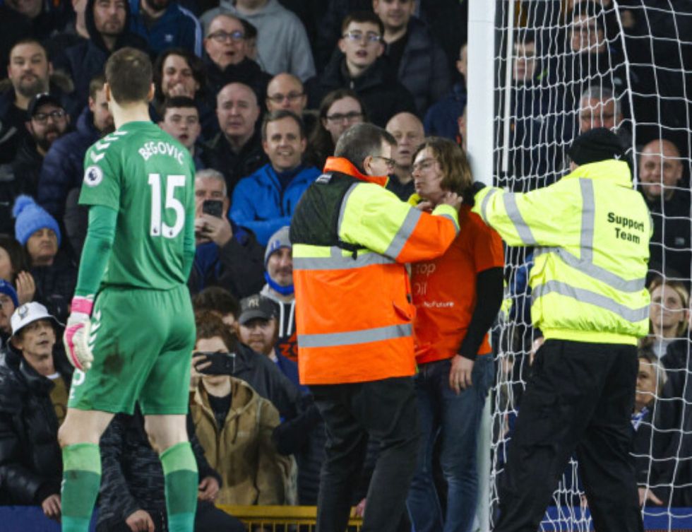 Louis McKechnie ties himself to the goal frame during the Premier League match at Goodison Park, Liverpool. Picture date: Thursday March 17, 2022