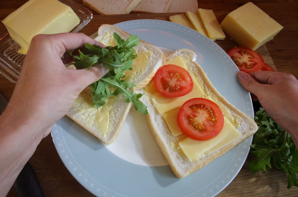 Making a sandwich using cheese, tomato and white bread