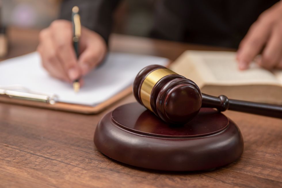 Male lawyer working with contract papers and wooden gavel on tabel in courtroom