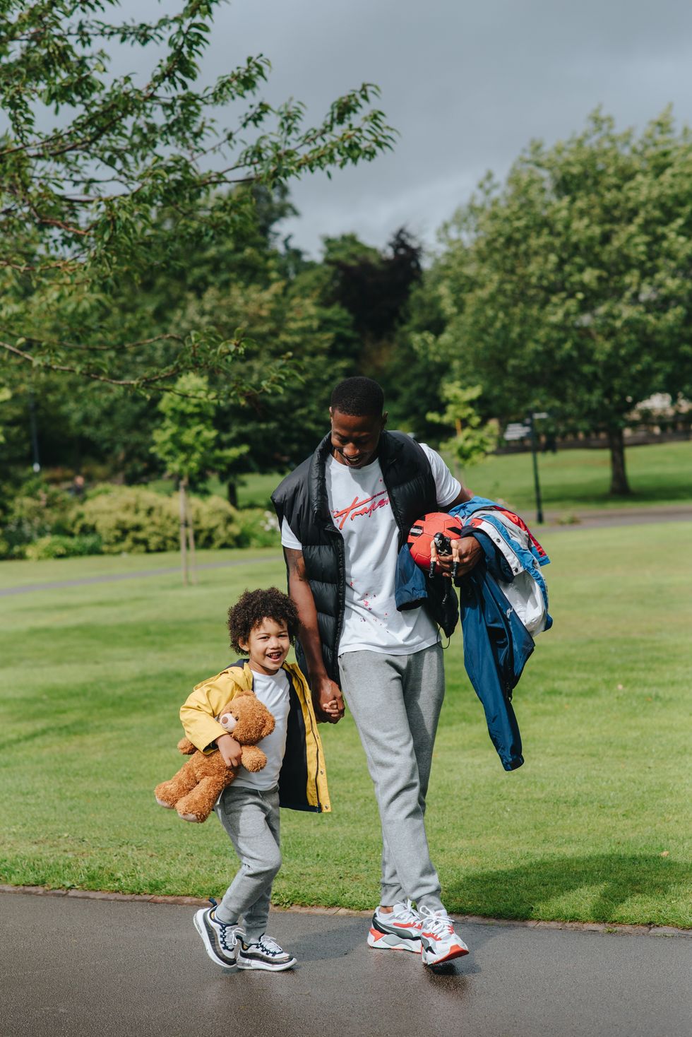 Man and child walking in park