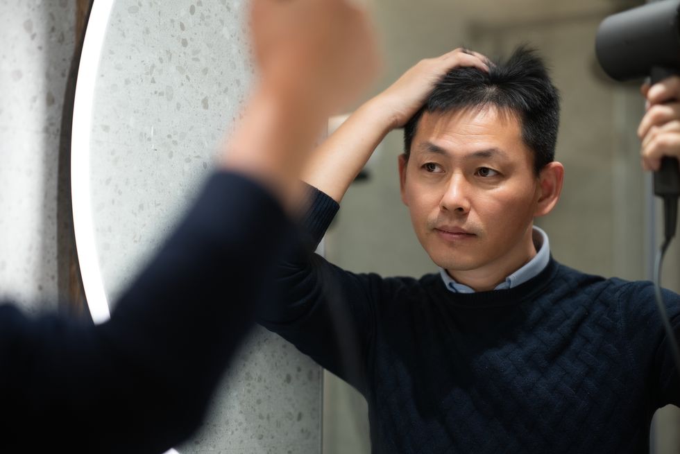Man blow drying his hair