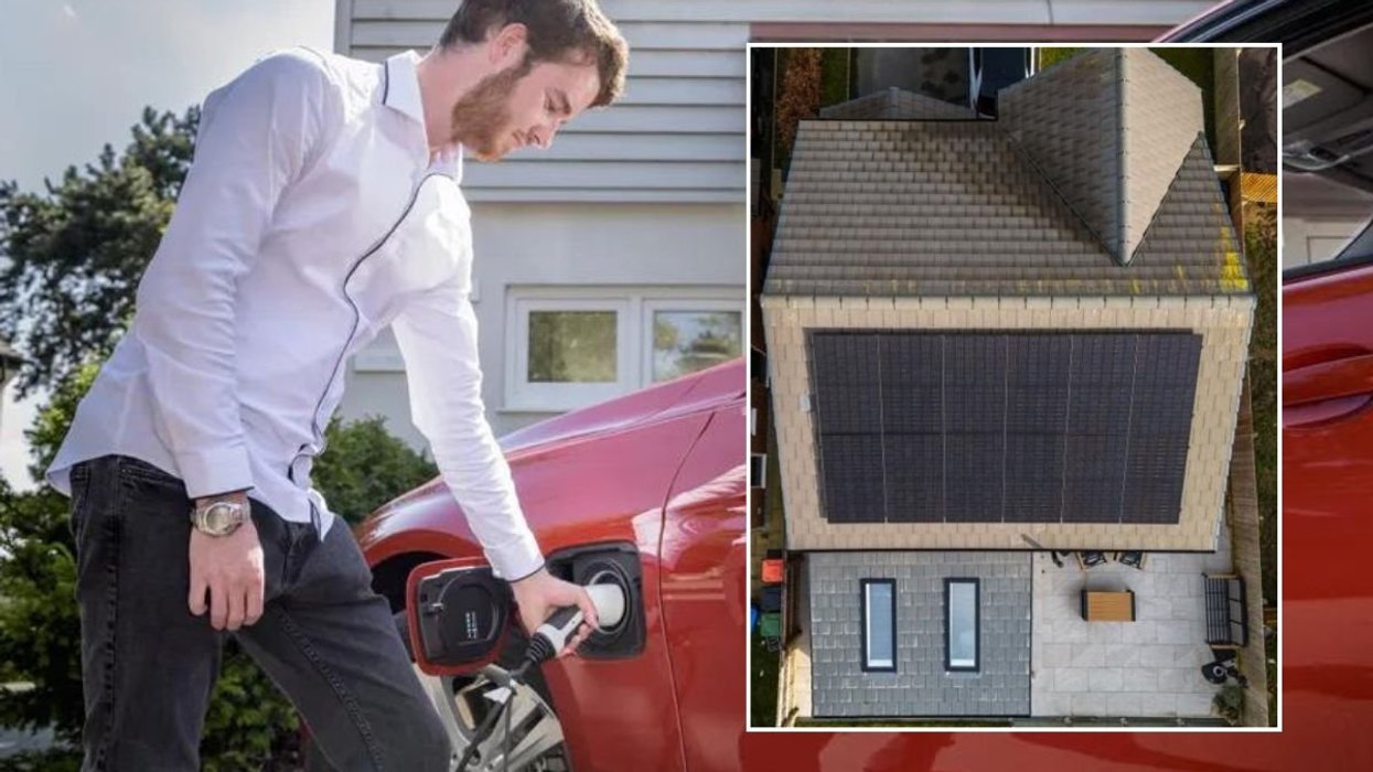 Man charging electric car at home and a house covered in solar panels