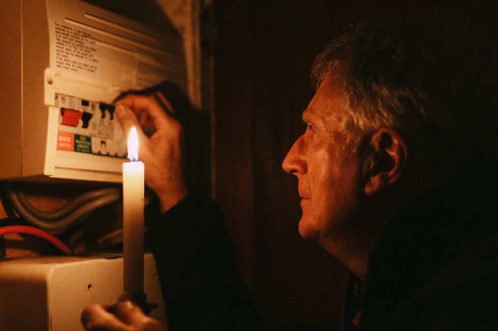 Man checks fuse box during power cut