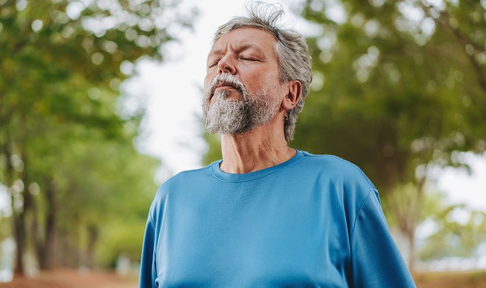 Man closing his eyes and inhaling deep breaths
