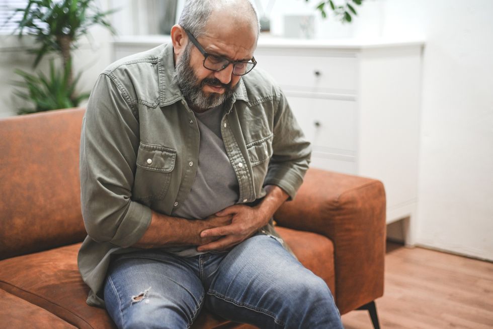 Man clutching his stomach in pain