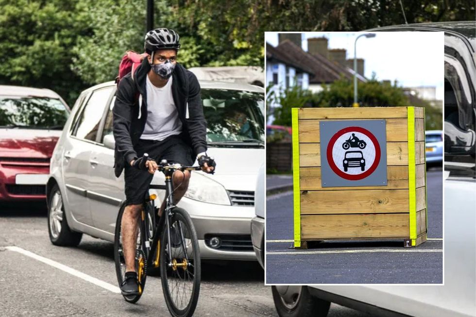 Man cycling in traffic and a no cars sign