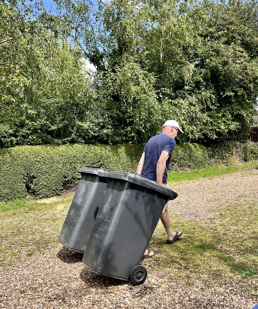 Man dragging bins