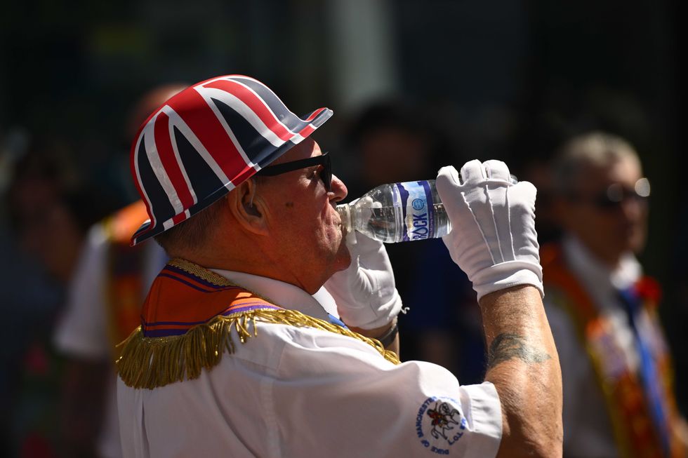 Man drinks water at July 12 parade