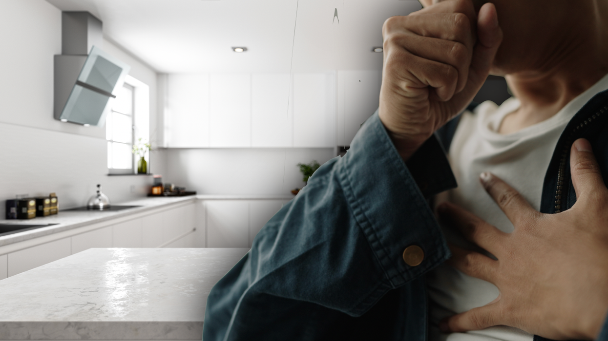 Man gripping his chest in a kitchen