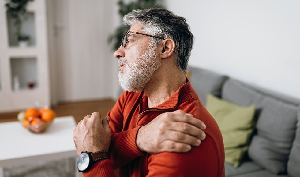 Man gripping his shoulder in pain